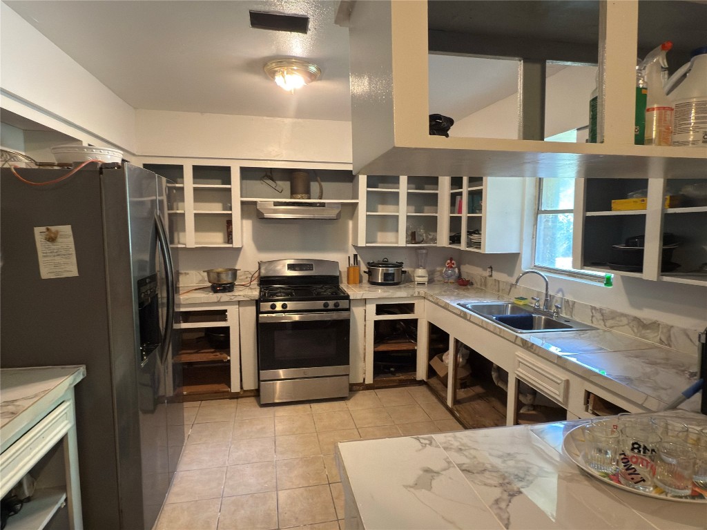 10106 Cheeves Drive Houston, TX 77016 - Photo 6 of 12 a kitchen with stainless steel appliances granite countertop a stove and a refrigerator