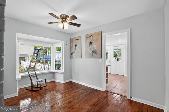a view of a livingroom with wooden floor and a ceiling fan