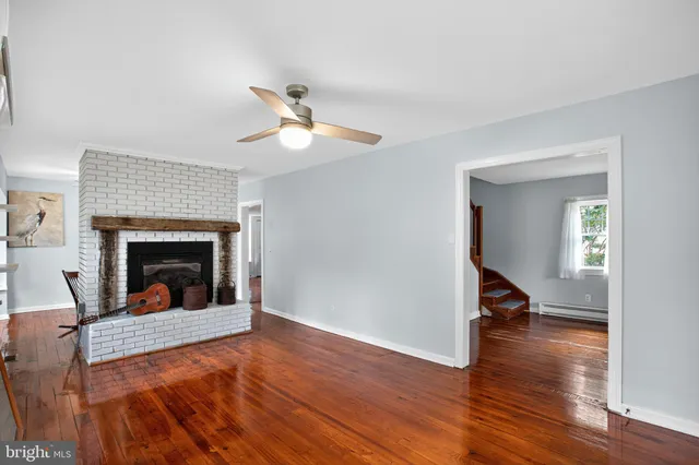 a view of a livingroom with a fireplace a ceiling fan and a rug