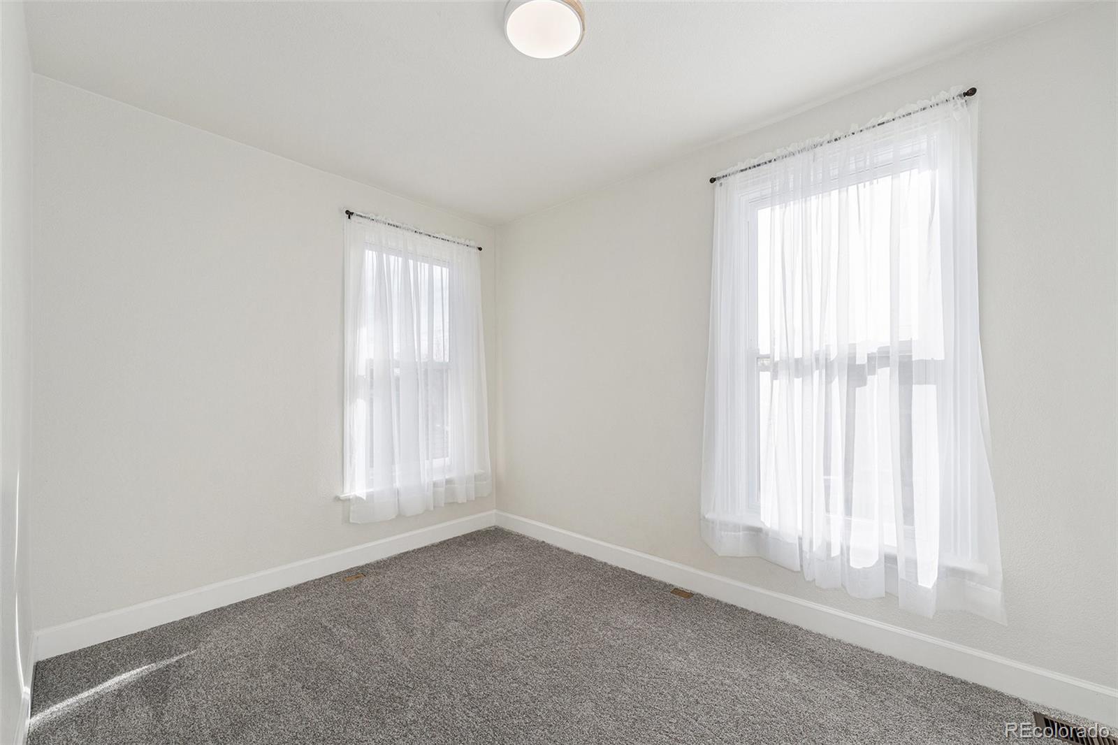 300 Inca Street Denver, CO 80223 - Photo 11 of 20 an empty room with wooden floor and windows