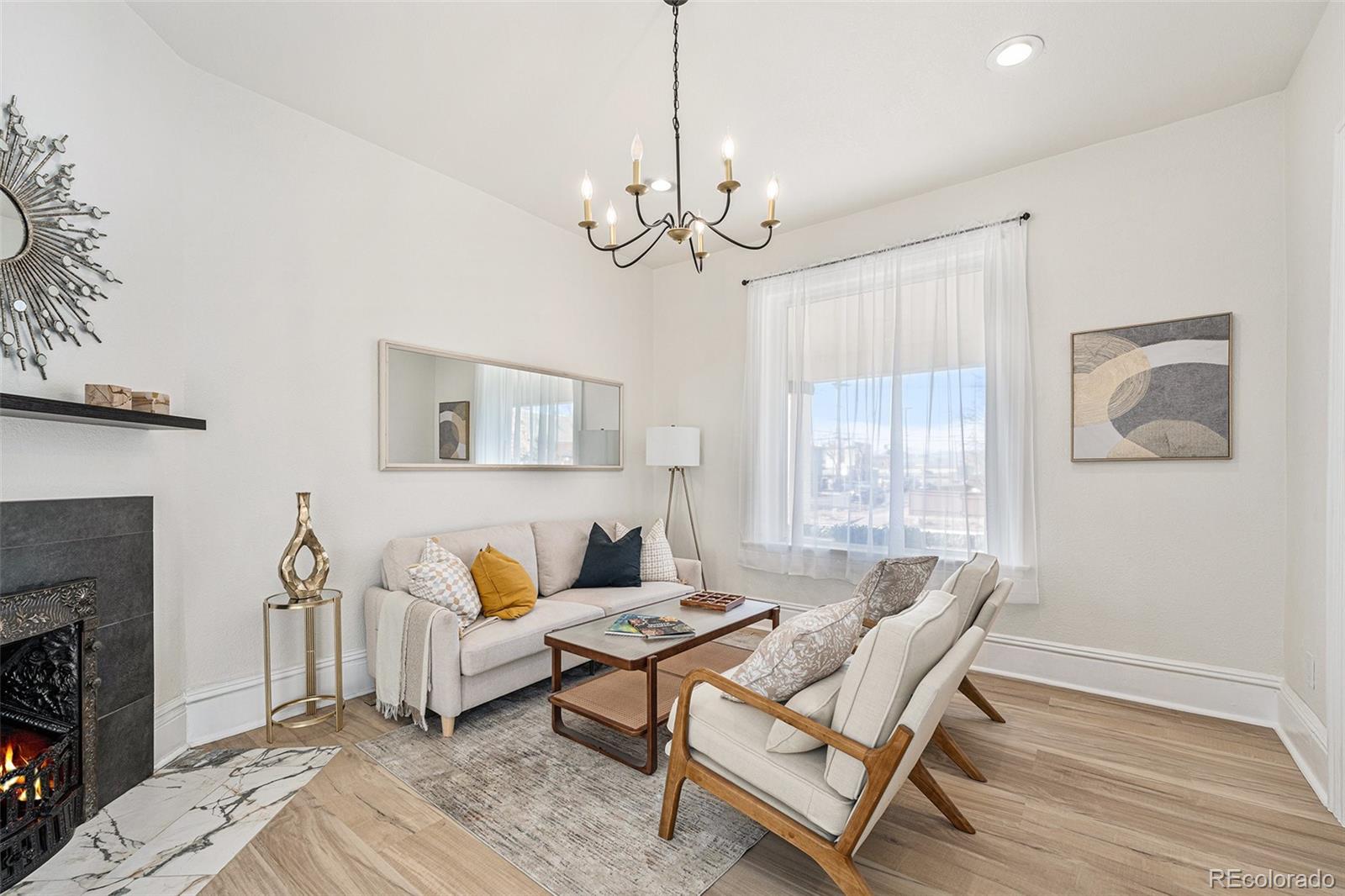 300 Inca Street Denver, CO 80223 - Photo 3 of 20 a living room with furniture a chandelier and a fireplace