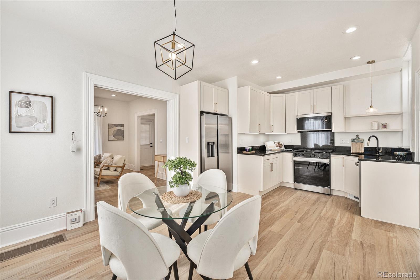 300 Inca Street Denver, CO 80223 - Photo 5 of 20 a kitchen with granite countertop white cabinets stainless steel appliances and dining table