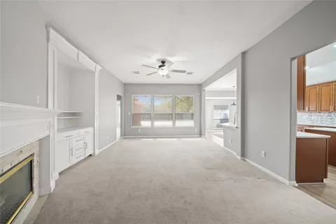 a view of empty room with windows and ceiling fan