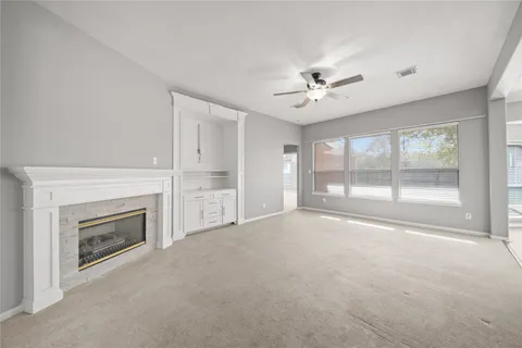 a spacious bedroom with a bed a mirror on dresser and a chandelier