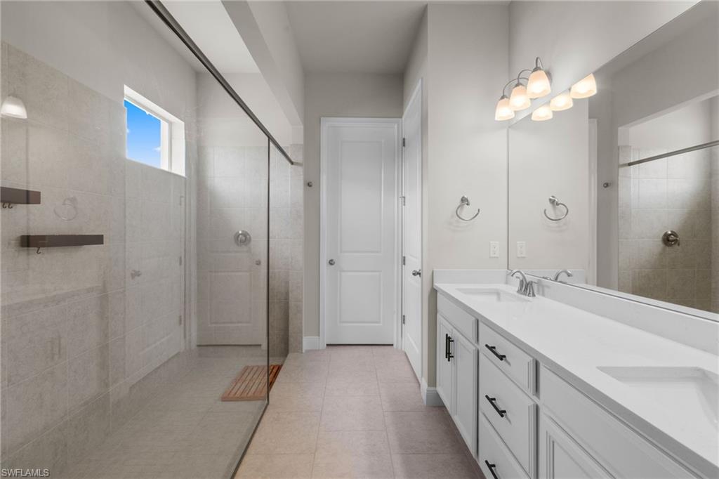 3419 Pilot Circle Naples, FL 34120 - Photo 16 of 39 a spacious bathroom with a double vanity sink a large mirror and shower
