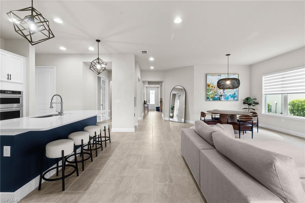 3419 Pilot Circle Naples, FL 34120 - Photo 19 of 39 a living room with furniture a chandelier and a dining table
