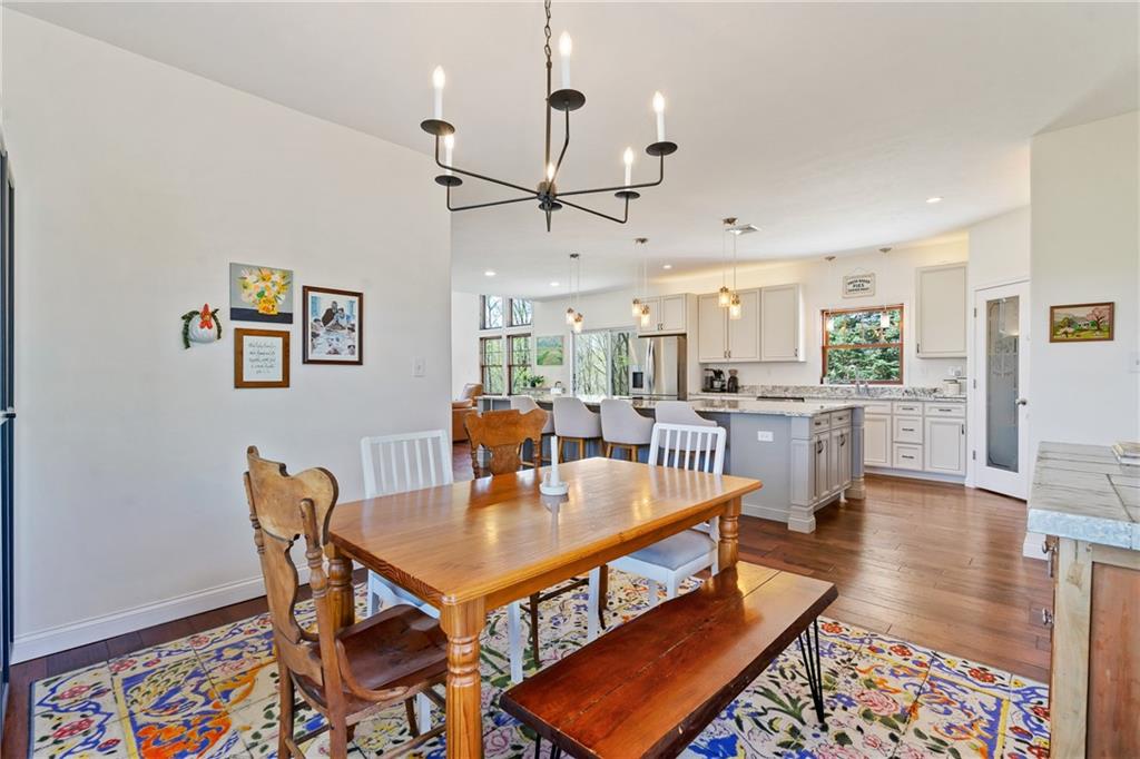 2175 Lovi Road Freedom, PA 15042 - Photo 14 of 36 a dining room with wooden floor a chandelier a wooden table and chairs