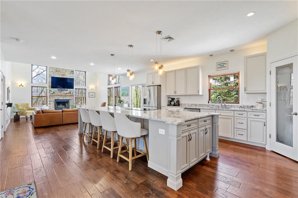 2175 Lovi Road Freedom, PA 15042 - Photo 8 of 36 a kitchen with stainless steel appliances kitchen island granite countertop a stove a sink a refrigerator and white cabinets with wooden floor