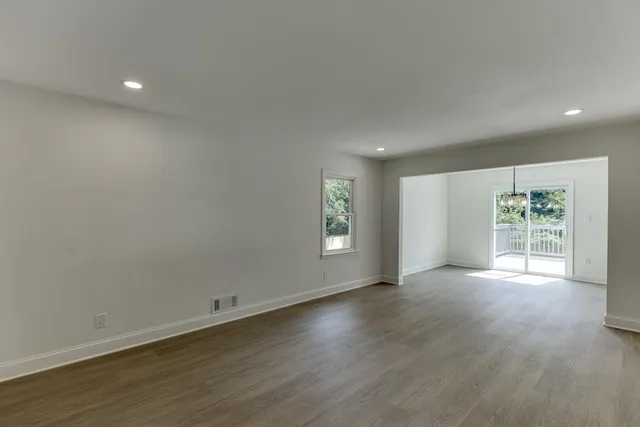 an empty room with large window and wooden floor
