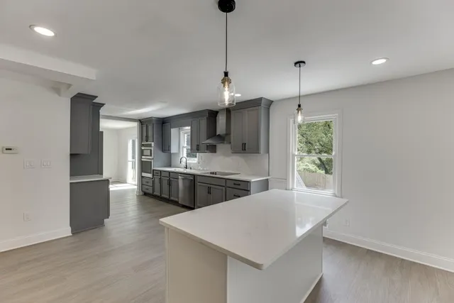 a large kitchen with stainless steel appliances a stove refrigerator and a microwave