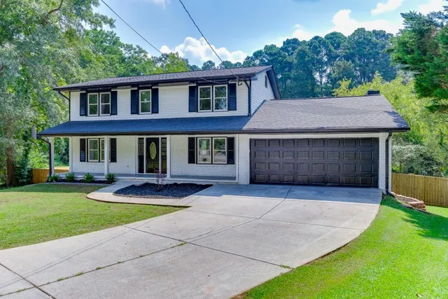 a front view of a house with yard and green space