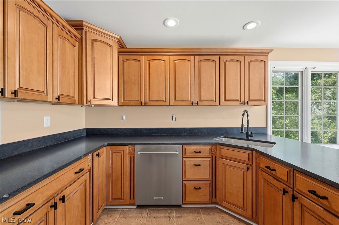 7750 Lewis Road Olmsted Falls, OH 44138 - Photo 15 of 50 Kitchen featuring light wood cabinetry with black hardware, dark countertops, and stainless steel dishwasher