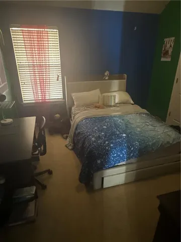 a bedroom with a bed and window