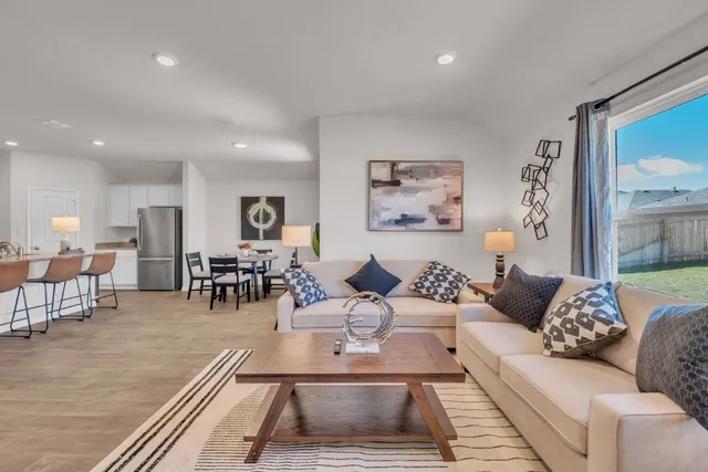a living room with furniture and view of kitchen