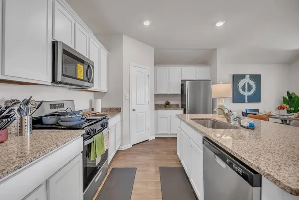 a kitchen with stainless steel appliances granite countertop a sink stove and refrigerator