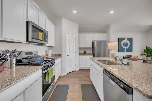 a kitchen with stainless steel appliances granite countertop a sink stove and refrigerator