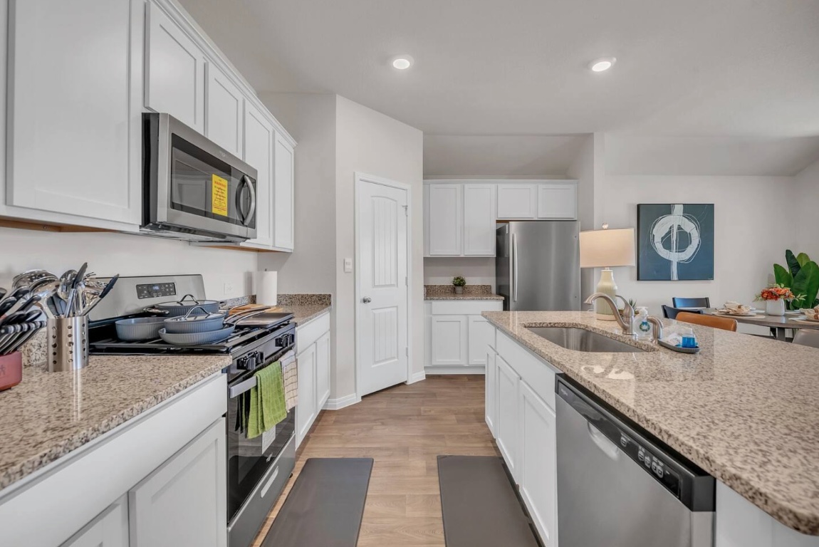 13804 Bothwell Place Manor, TX 78653 - Photo 3 of 7 a kitchen with stainless steel appliances granite countertop a sink stove and refrigerator