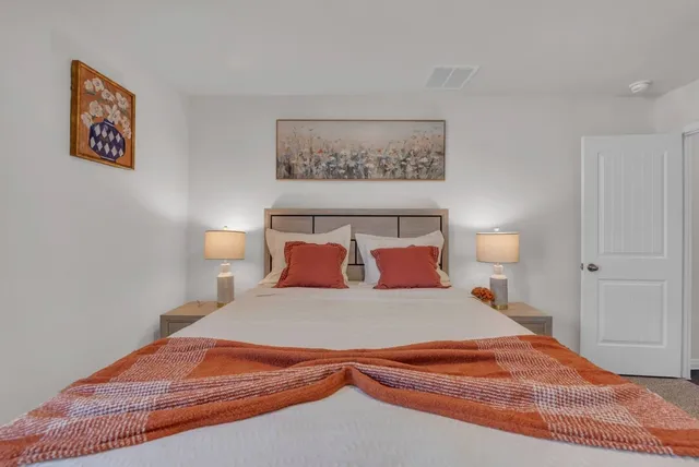 a bedroom with a bed and a night stand