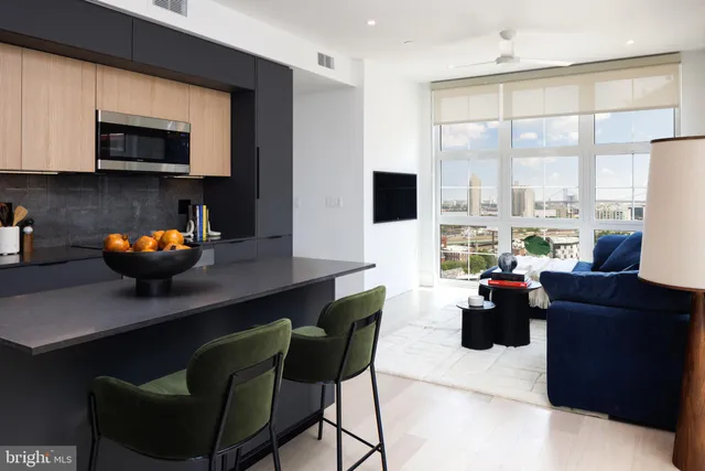 a living room with furniture a flat screen tv and kitchen view