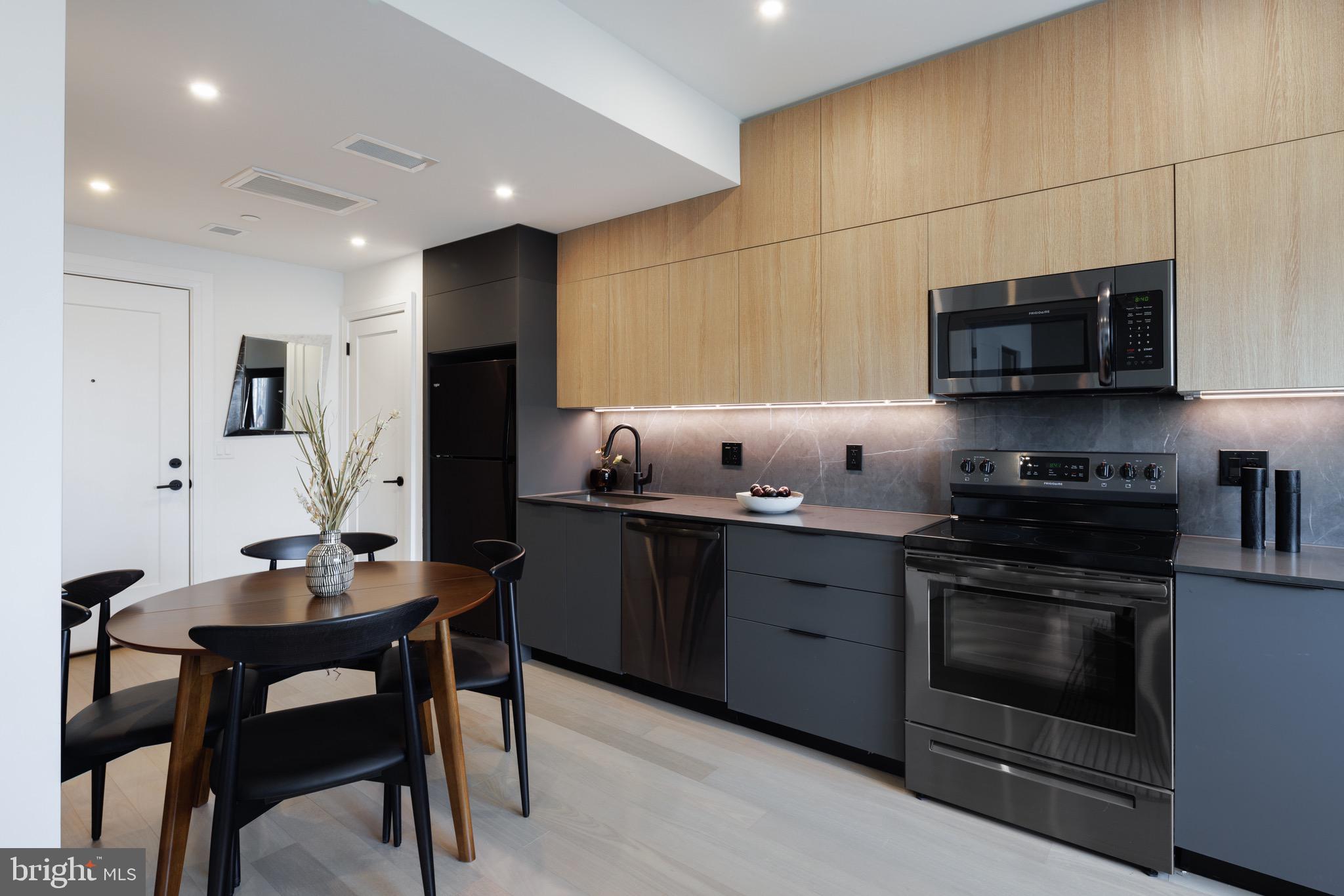 1099 Germantown Avenue, Unit A Philadelphia, PA 19123 - Photo 6 of 53 a kitchen with stainless steel appliances a stove a sink cabinets and a dining table