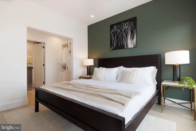 a large bed sitting in a bedroom and a table