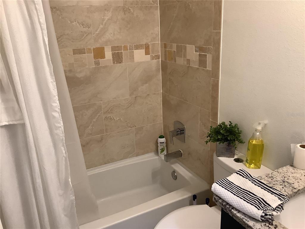 1150 North Dean Road Orlando, FL 32825 - Photo 14 of 16 a bathroom with a white tub shower and a sink