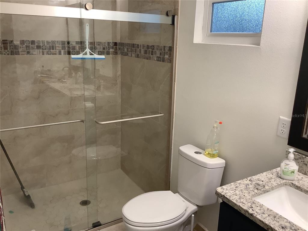 1150 North Dean Road Orlando, FL 32825 - Photo 16 of 16 a bathroom with a granite countertop sink a toilet and shower