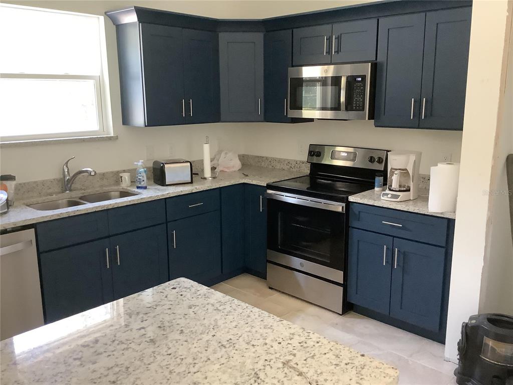 1150 North Dean Road Orlando, FL 32825 - Photo 9 of 16 a kitchen with a sink stove and microwave