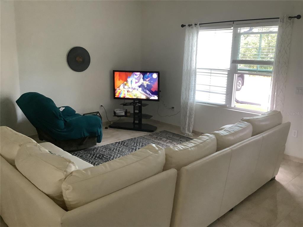 1150 North Dean Road Orlando, FL 32825 - Photo 10 of 16 a living room with furniture and a flat screen tv