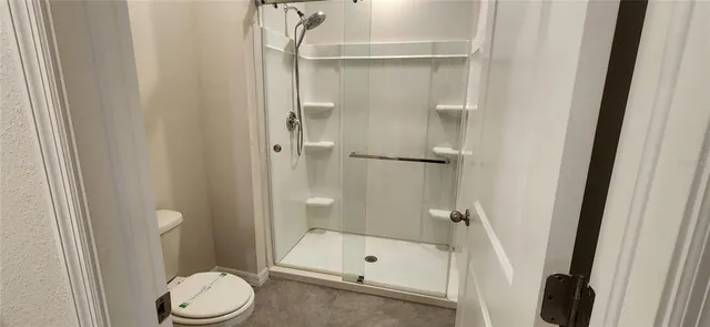 a bathroom with a toilet and a shower