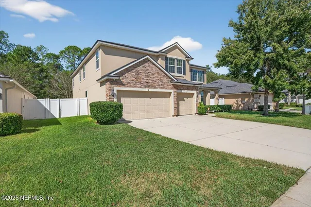 a front view of a house with a garden and plants