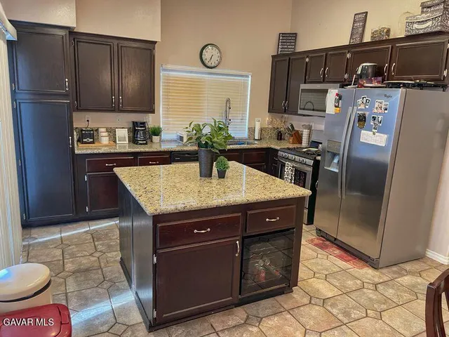 a kitchen with granite countertop a sink a stove and a refrigerator