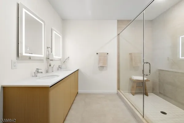 a bathroom with a granite countertop sink a mirror and shower