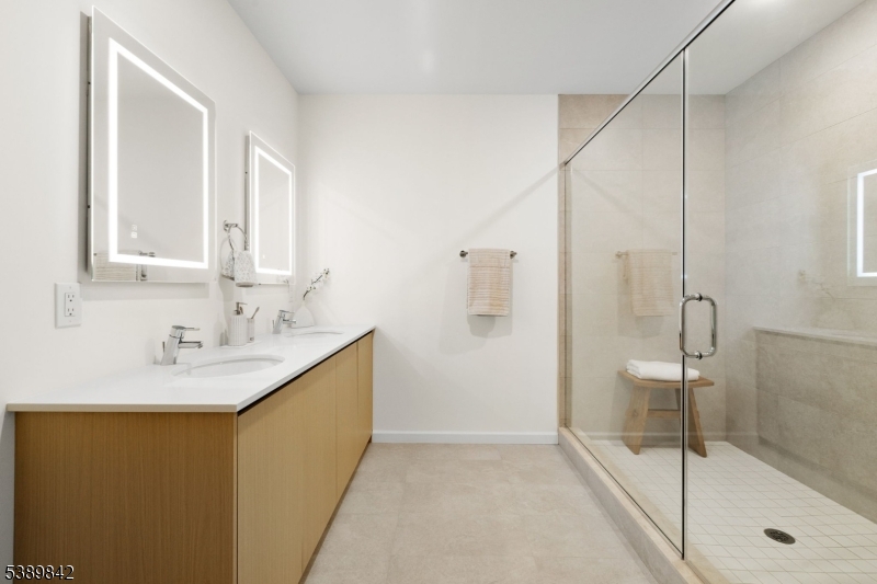 70 Ridgedale Avenue, Unit 205 Morristown, NJ 07960 - Photo 15 of 20 a bathroom with a granite countertop sink a mirror and shower