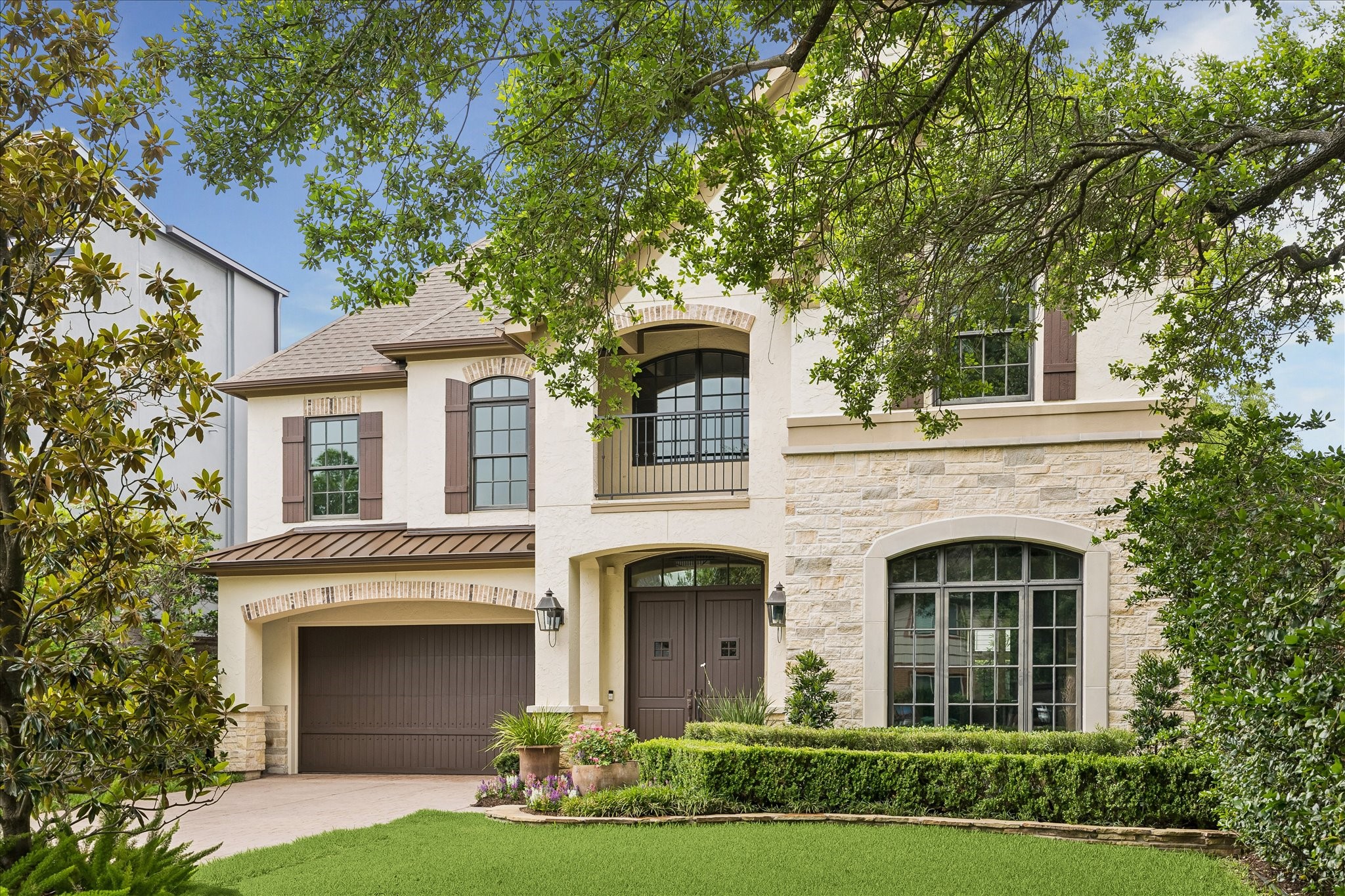 2246 Branard Street Houston, TX 77098 - Photo 40 of 40 Framed by mature trees, the front elevation highlights stone accents, arched windows, and a welcoming entry to your new home.