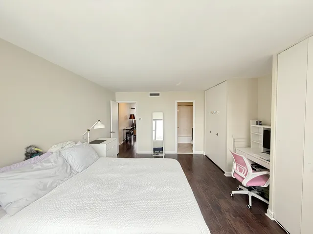 a bedroom with a bed lamp and a window