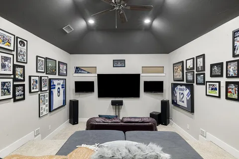 a living room with stainless steel appliances furniture and a flat screen tv