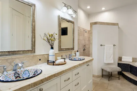 a bathroom with double vanity sinks a mirror and a shower