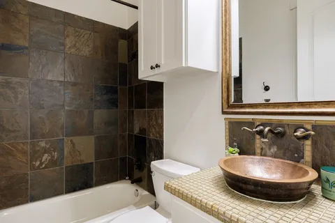 a bathroom with a granite countertop bathtub and sink