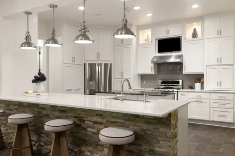 a kitchen with stainless steel appliances granite countertop a sink a stove and a wooden floor