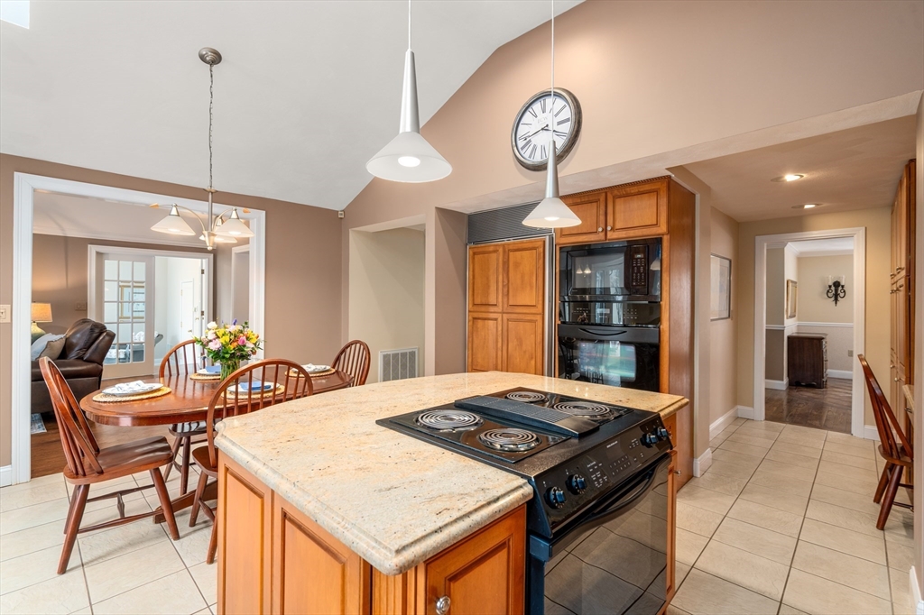 50 Stock Farm Road Sudbury, MA 01776 - Photo 11 of 40 a kitchen with stainless steel appliances granite countertop a stove a refrigerator a oven a dining table and chairs with wooden floor