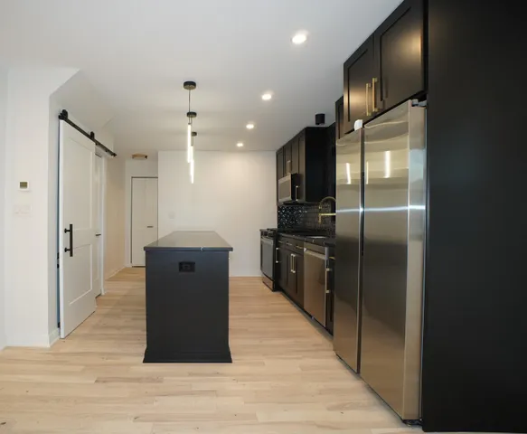 a kitchen with stainless steel appliances granite countertop a refrigerator and a sink