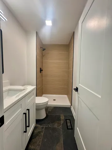 a bathroom with a double vanity sink toilet and shower