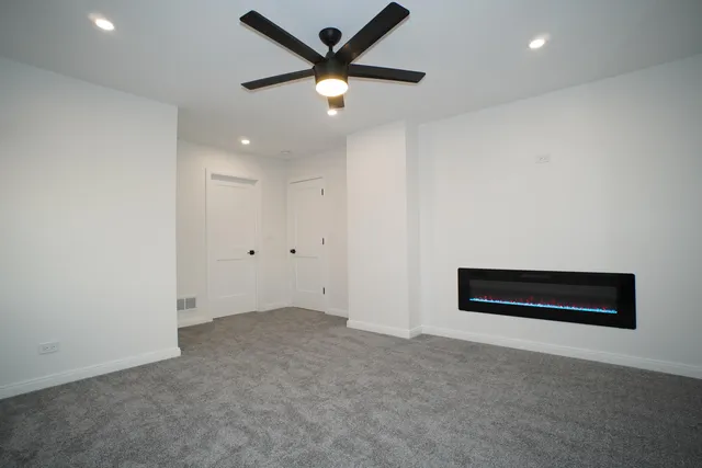 an empty room with closet and a ceiling fan