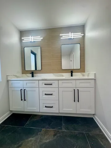 a bathroom with a sink a mirror and cabinets