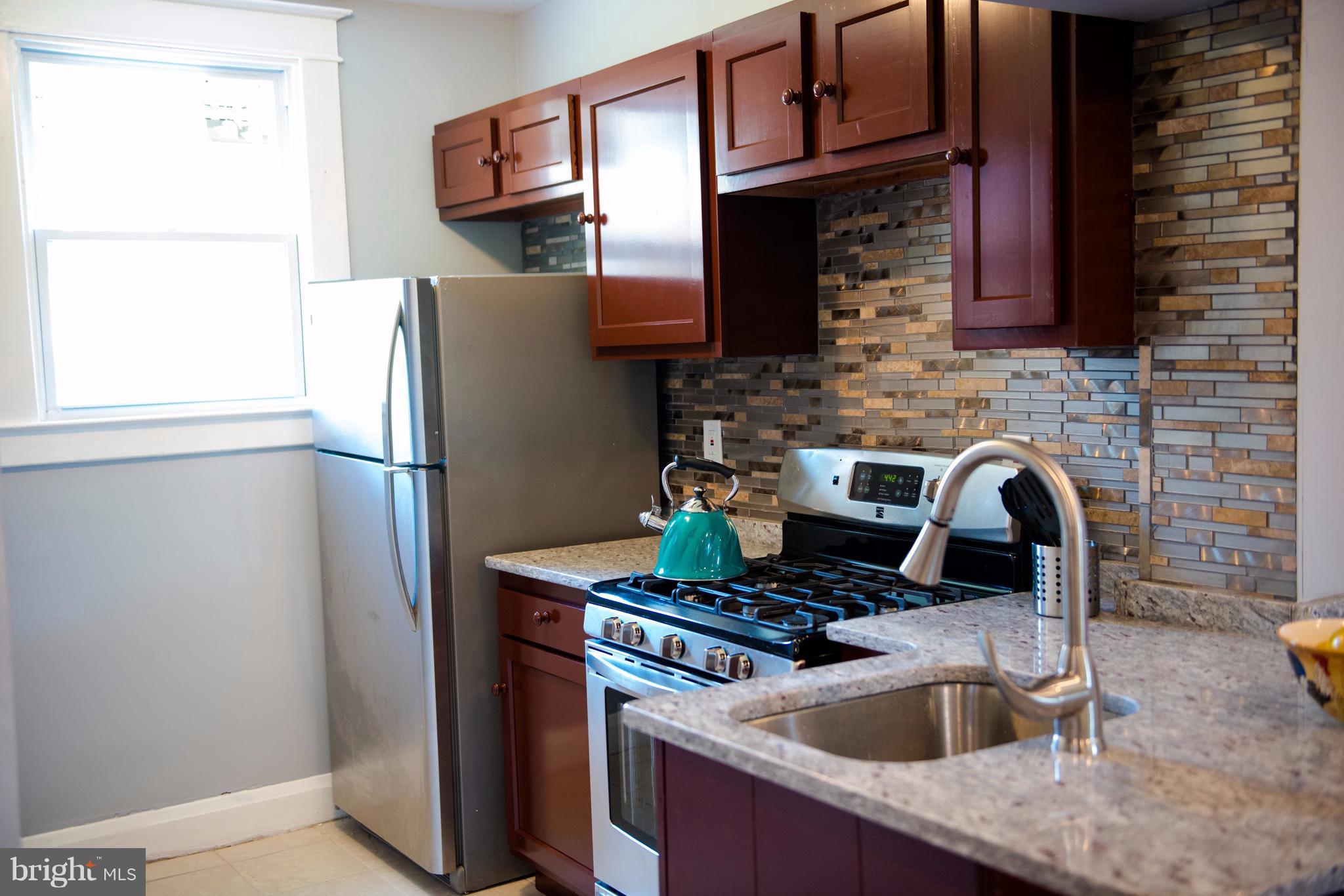764 Edgewood Street Baltimore, MD 21229 - Photo 2 of 25 a kitchen with stainless steel appliances granite countertop a refrigerator and a sink