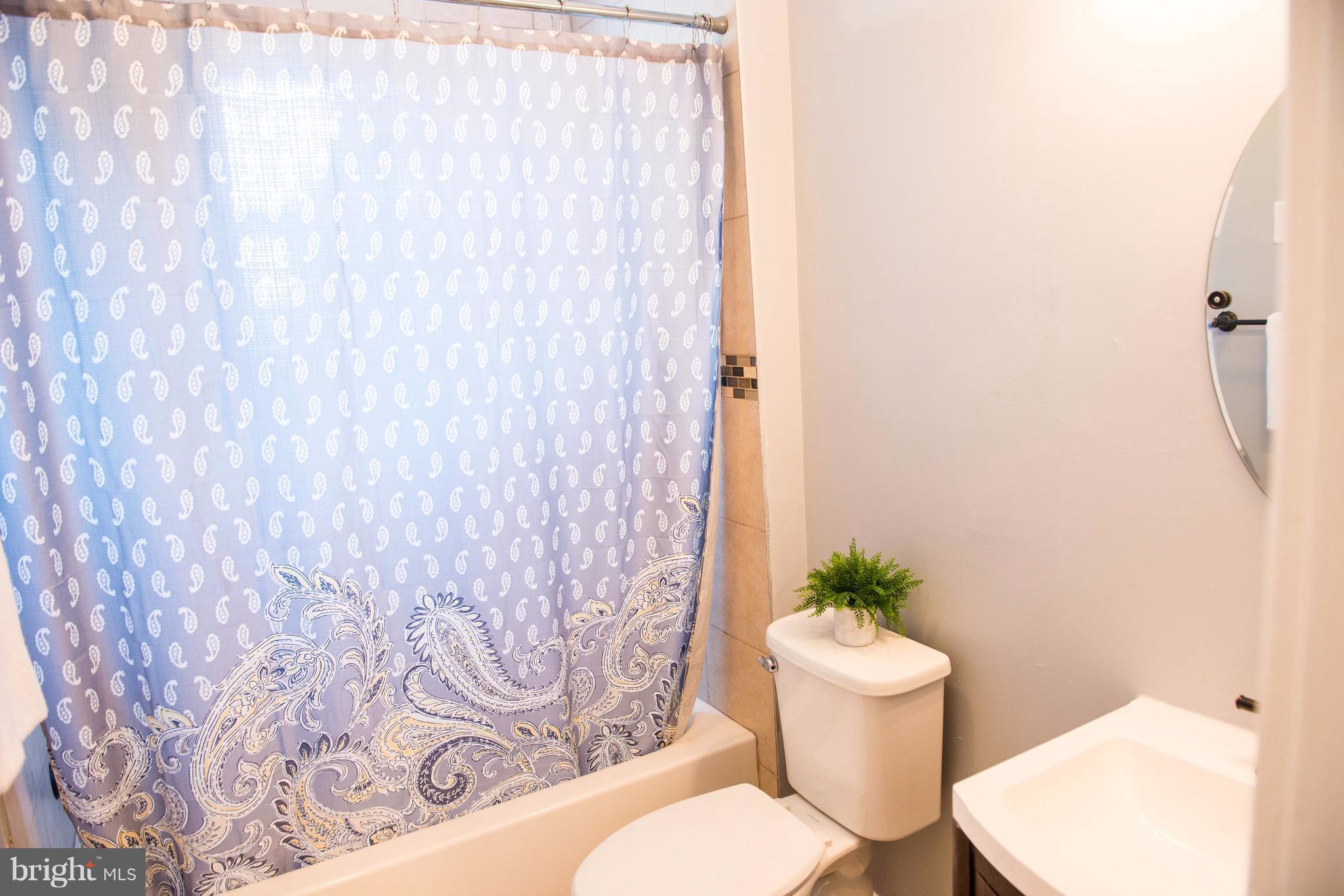 764 Edgewood Street Baltimore, MD 21229 - Photo 18 of 25 a bathroom with a toilet and a shower curtain
