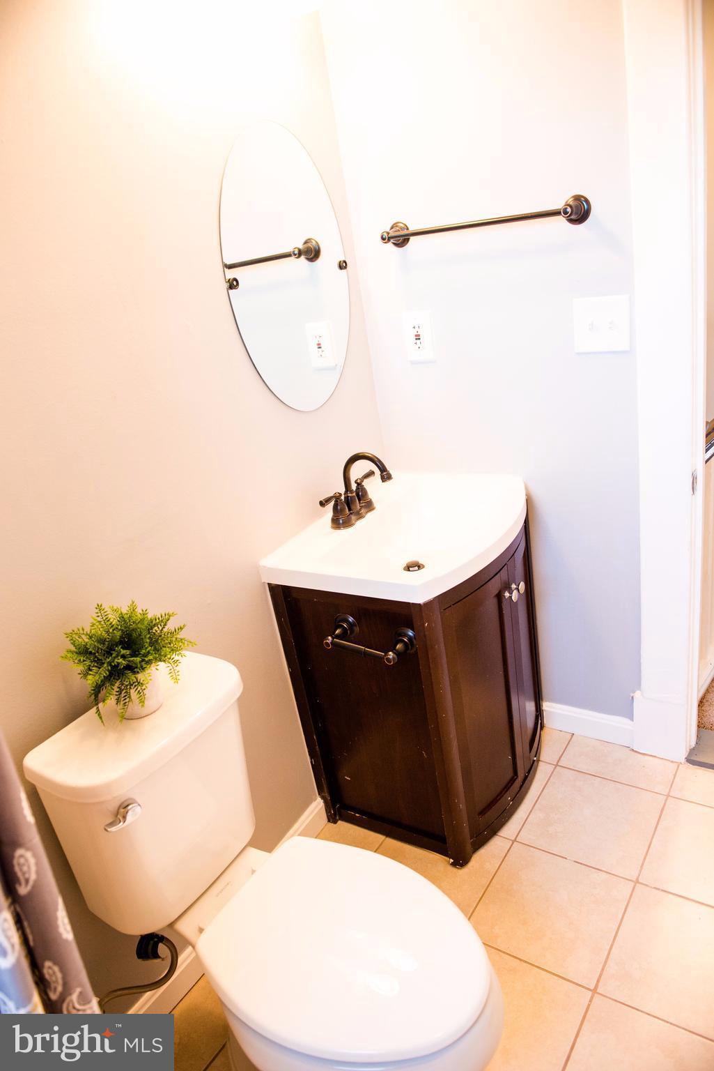 764 Edgewood Street Baltimore, MD 21229 - Photo 24 of 25 a bathroom with a sink mirror and vanity
