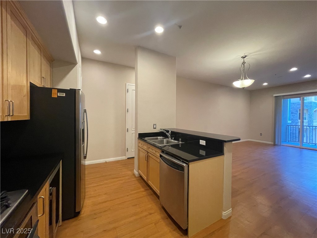 68 East Serene Avenue, Unit 225 Las Vegas, NV 89123 - Photo 22 of 22 Kitchen featuring dark countertops, recessed lighting, appliances with stainless steel finishes, light wood-type flooring, and open floor plan