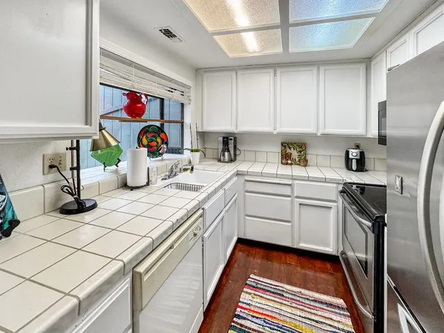 a kitchen with a sink appliances and cabinets